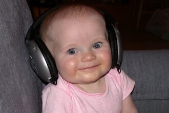cute baby listening to music ipod e1412721164710 تحسين قدرات الطفل اللغوية مجلة نقطة العلمية