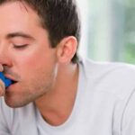man using asthma inhaler e1543562593797 بعض الطرق الطبيعية لتخفيف أعراض الربو مجلة نقطة العلمية