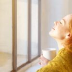 woman sitting in front of window خدعة ستساعدك في تعزيز التمثيل الغذائي وفقدان الوزن! مجلة نقطة العلمية