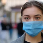 woman mask street crowd outdoors تحذير: جائحة COVID-19 لم تنته فاستعدو لما هو قادم! مجلة نقطة العلمية