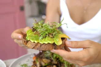 eating whole grain toast with avocado 5 أفضل الكربوهيدرات لتقليص دهون البطن وفقا لخبراء التغذية مجلة نقطة العلمية