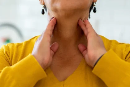 mature woman touching hands to her neck checking thyroid health 5 طرق طبيعية لإعادة شحن صحة الغدة الدرقية مجلة نقطة العلمية